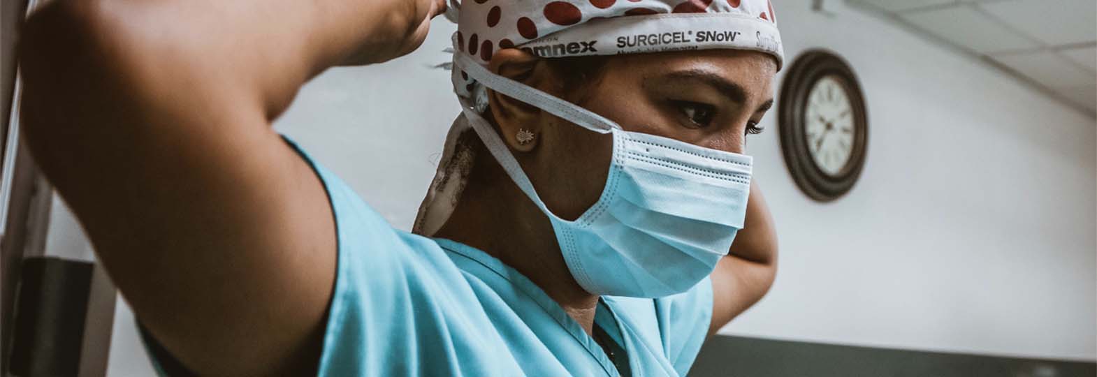 Photo of a doctor putting on mask before meeting patient
